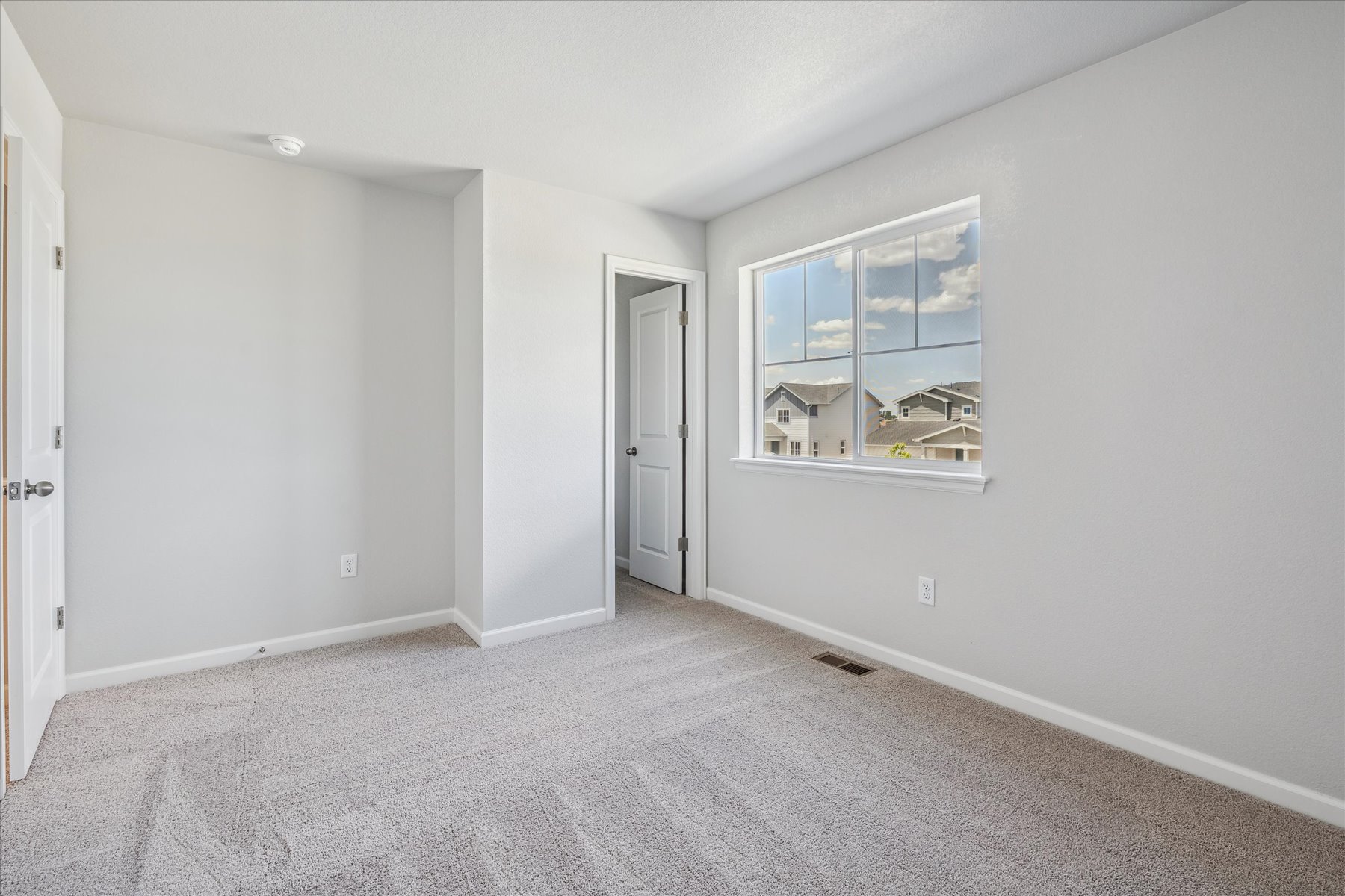 A room with a window and a carpet.
