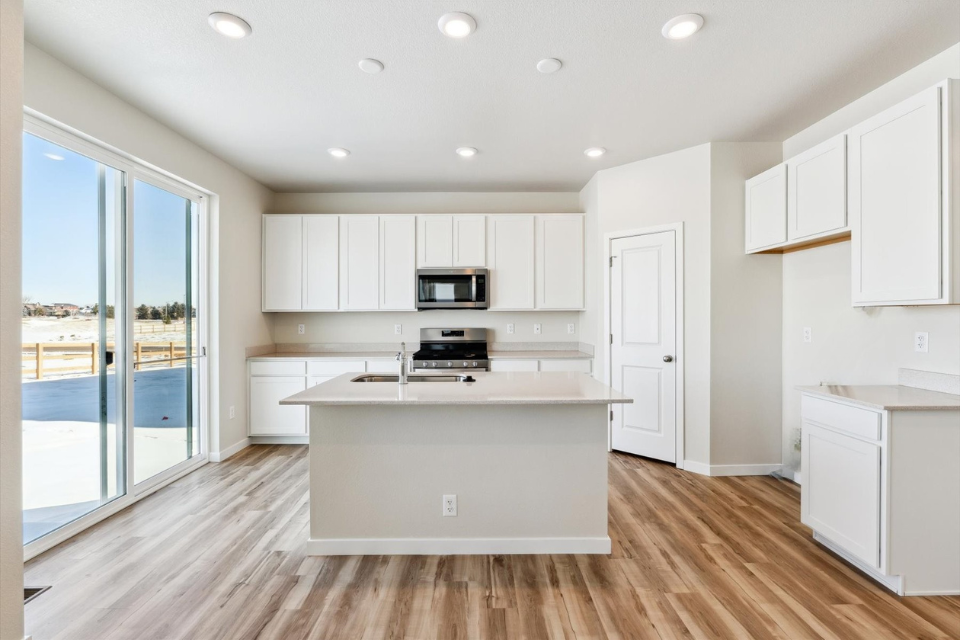 A kitchen with white cabinets.