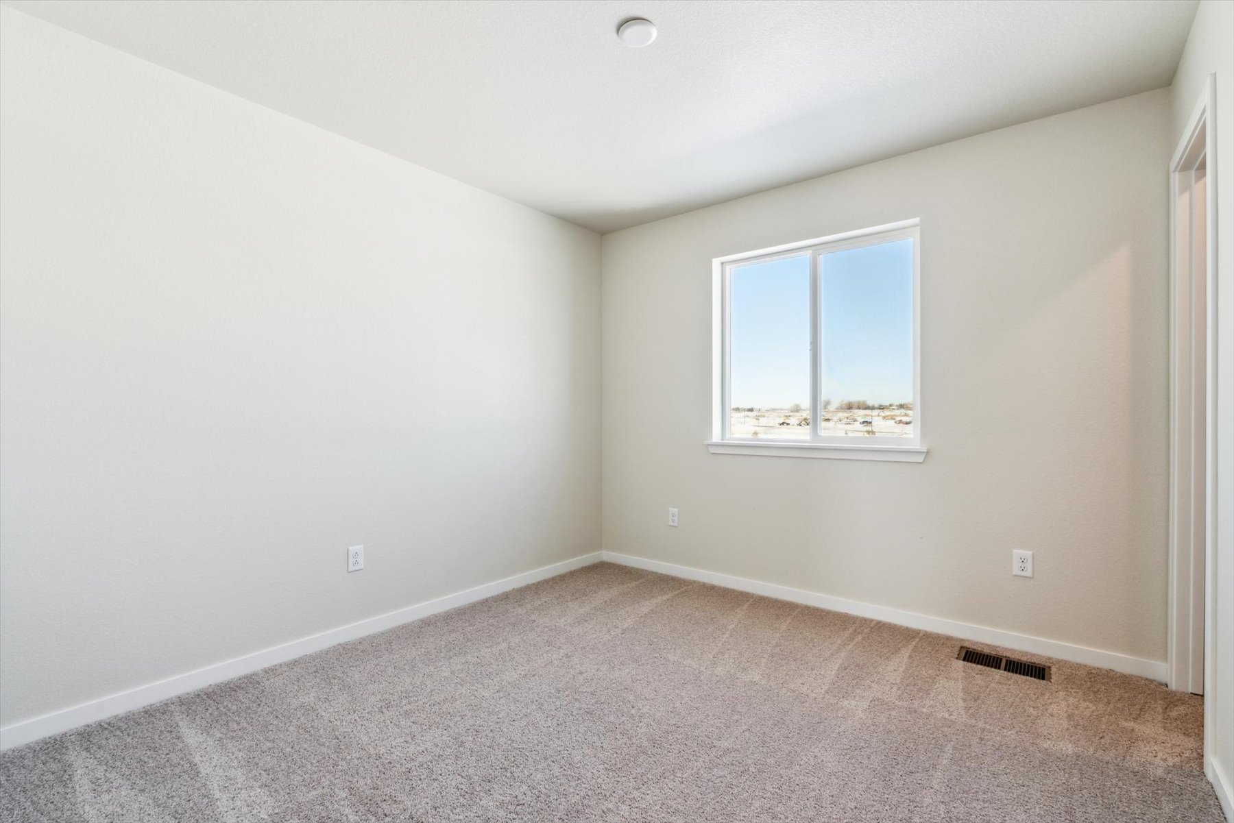 A room with a window and carpet.