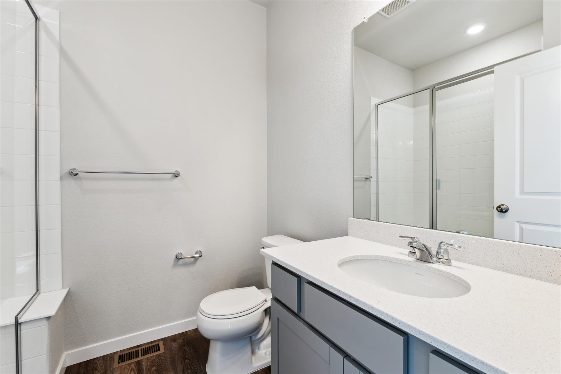 A bathroom with a sink toilet and mirror.