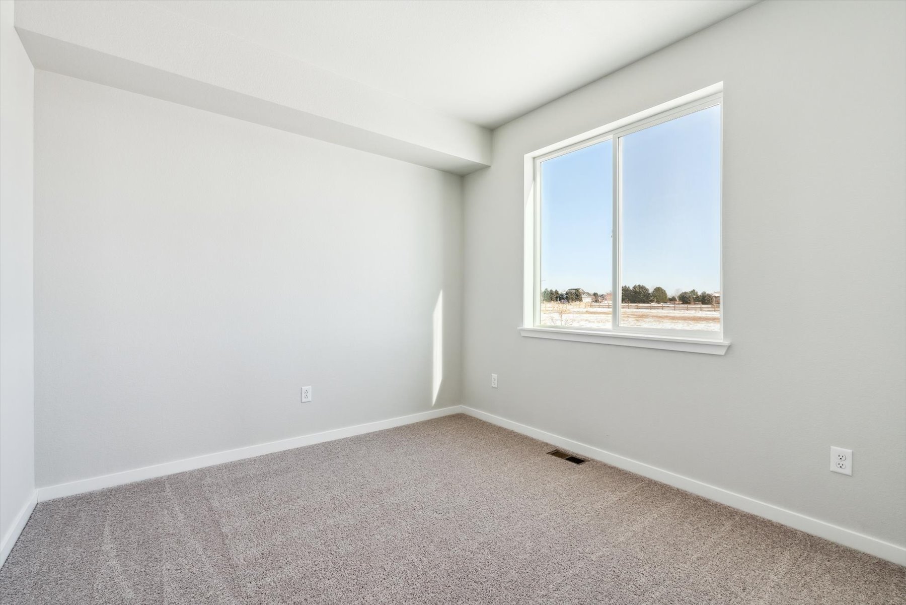 A room with a window and a carpet.
