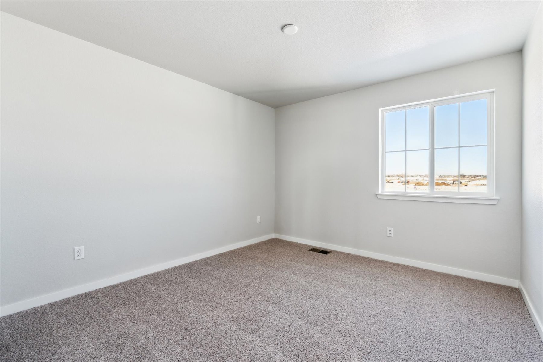 A room with a window and a carpet.
