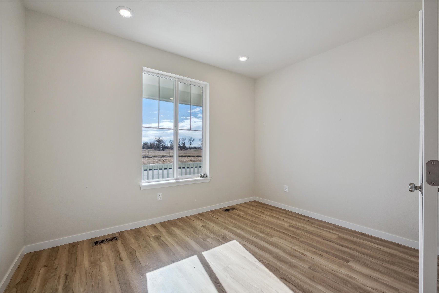 A room with a wood floor and a window.