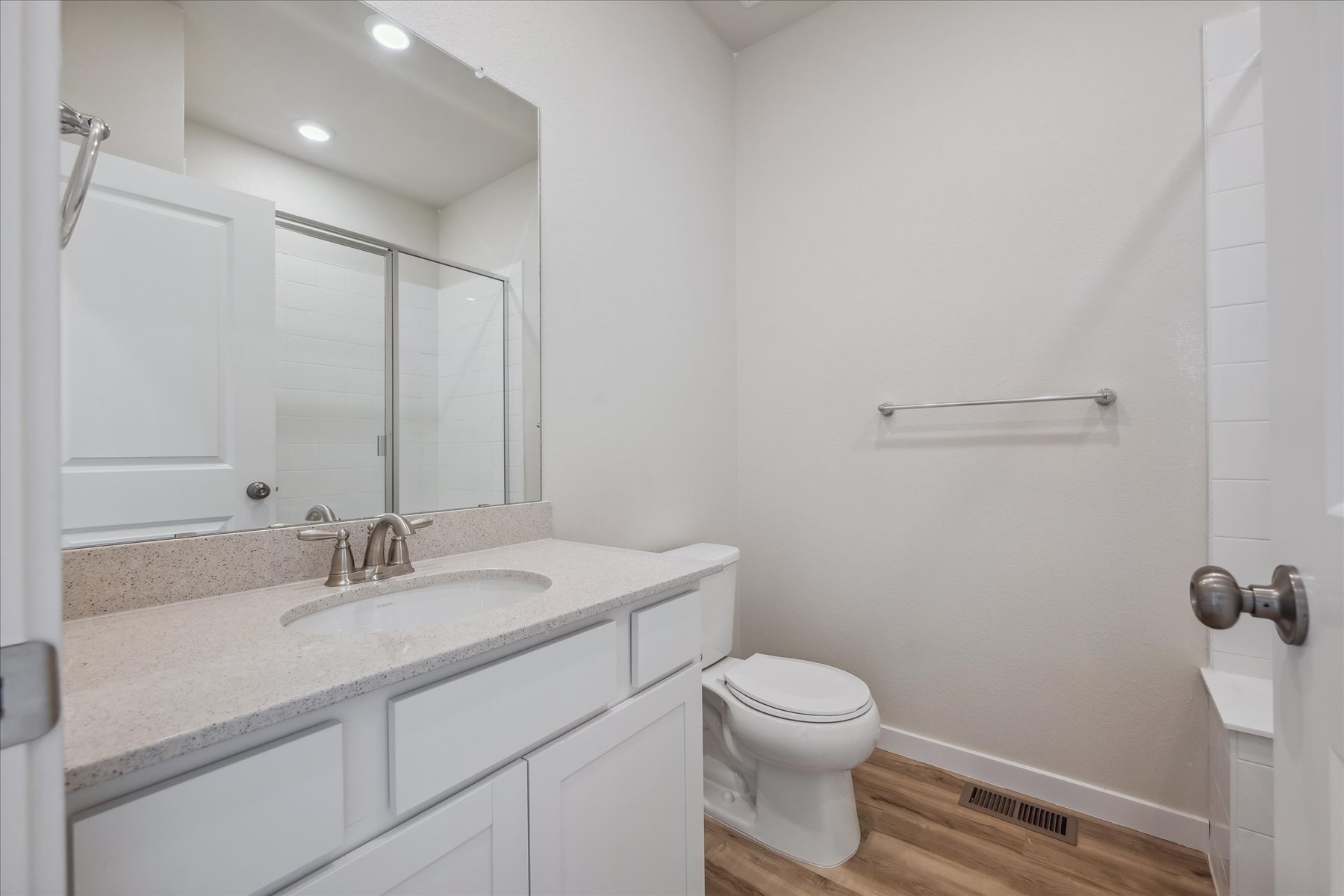 A bathroom with a sink toilet and mirror.