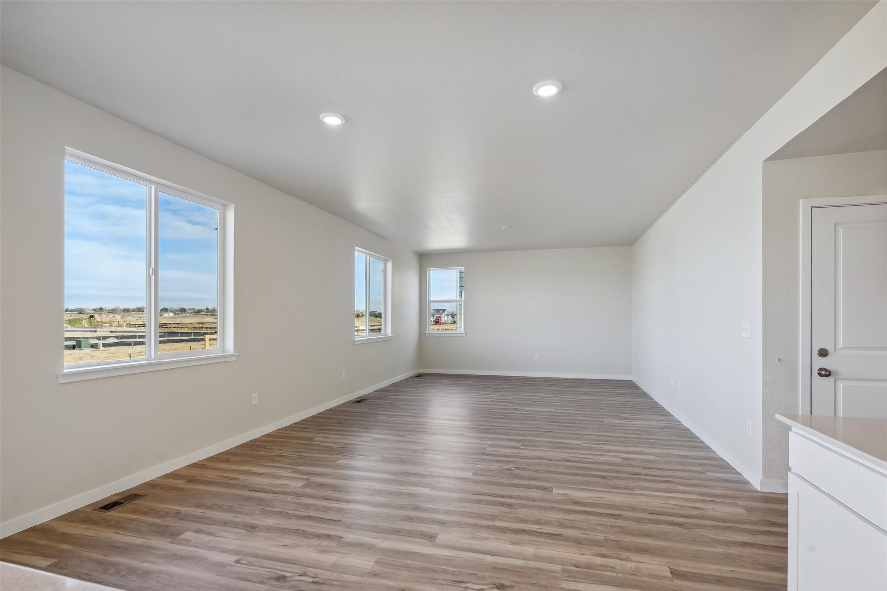 A room with a wood floor and windows.