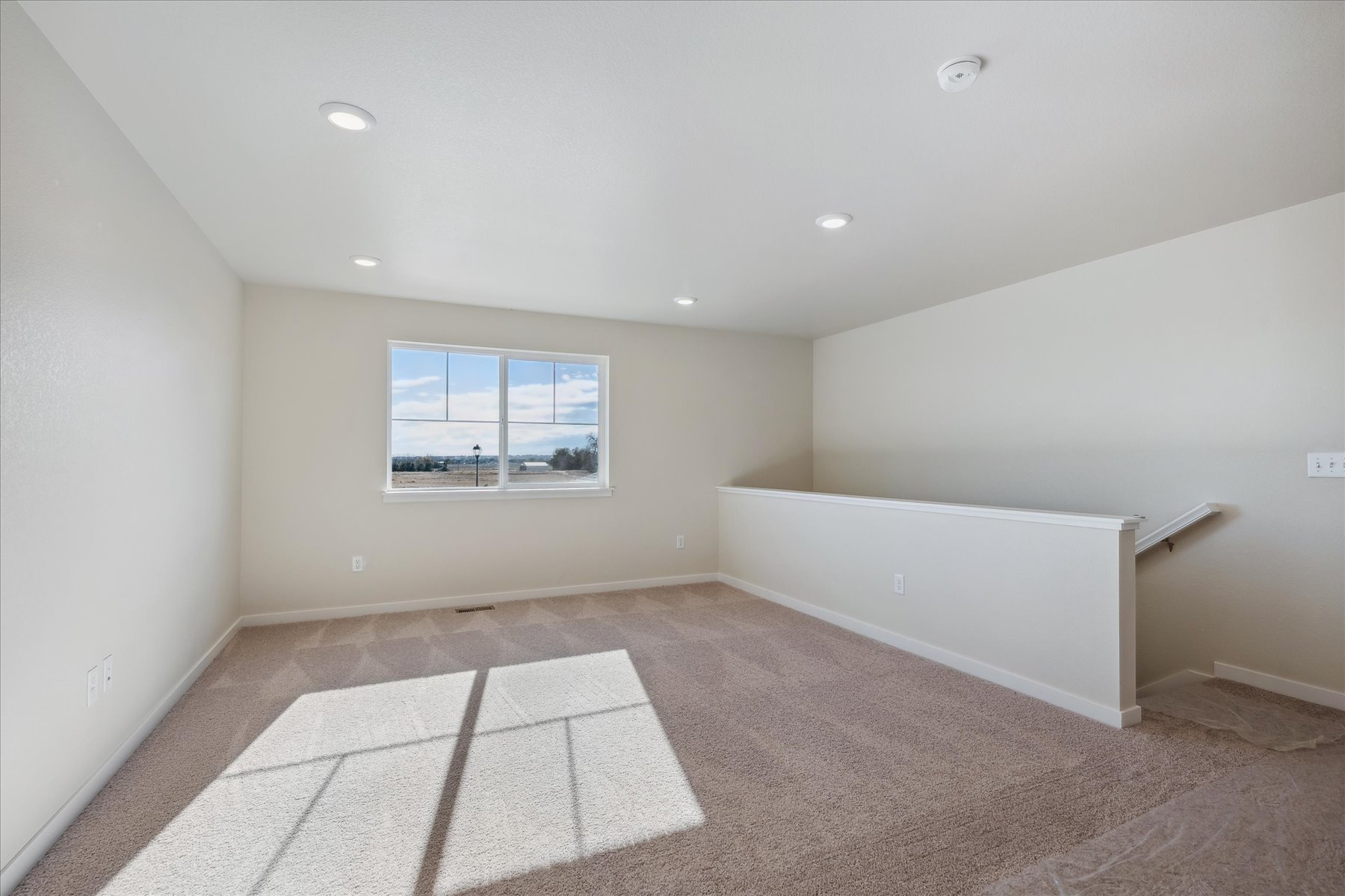 A room with a rug and a window.