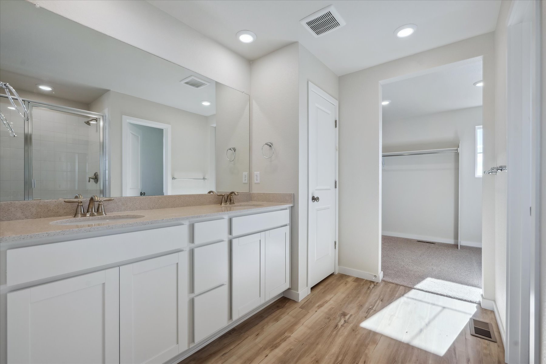 A bathroom with white cabinets.