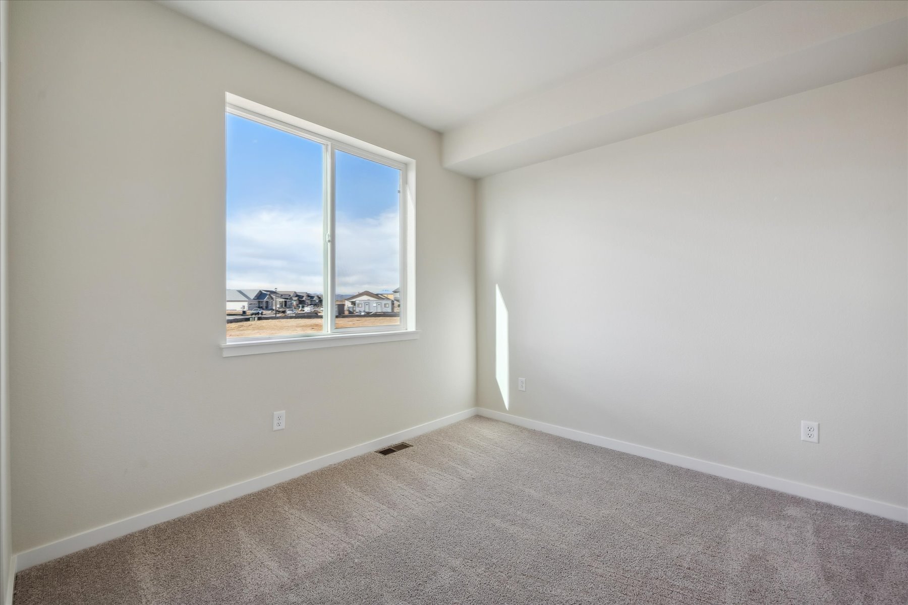 A room with a window and a carpet.