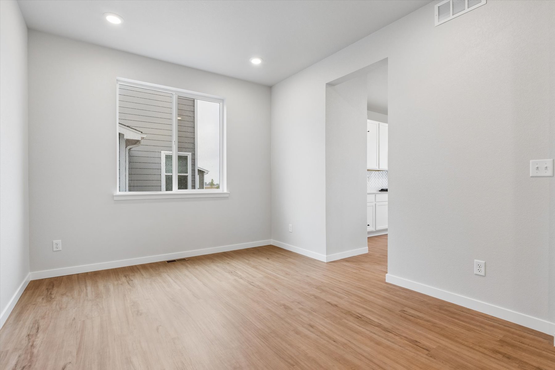 A room with a wood floor and a window.