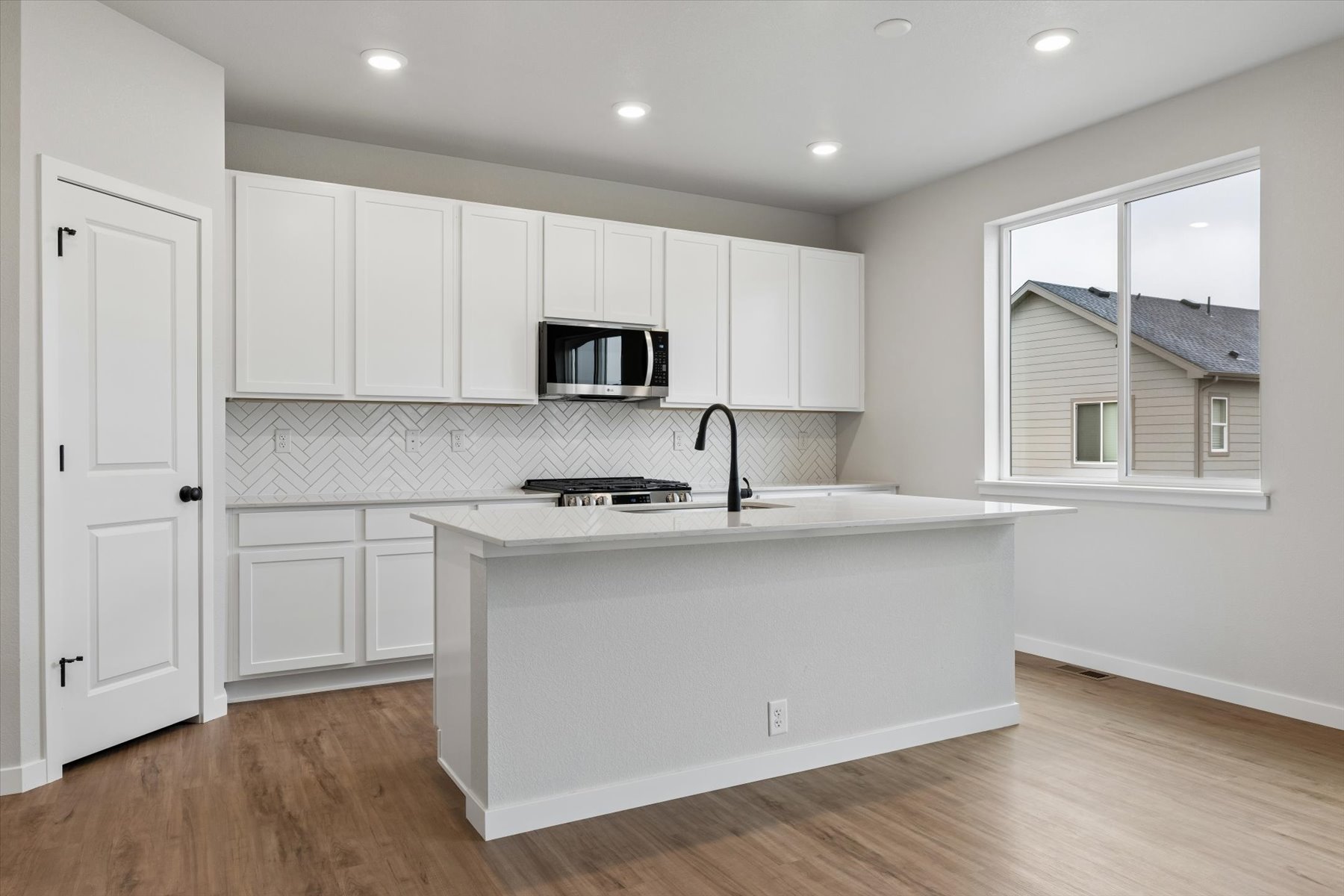 A kitchen with white cabinets.