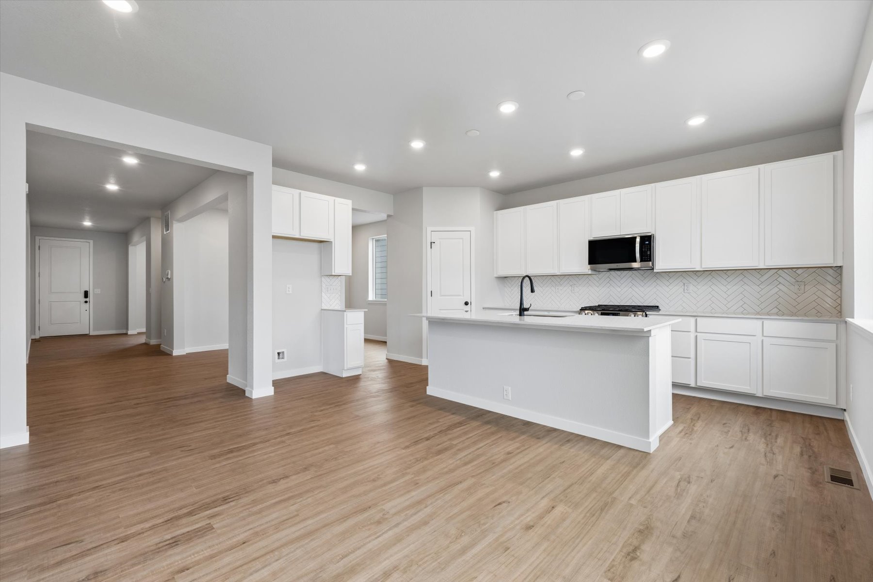 A kitchen with white cabinets.