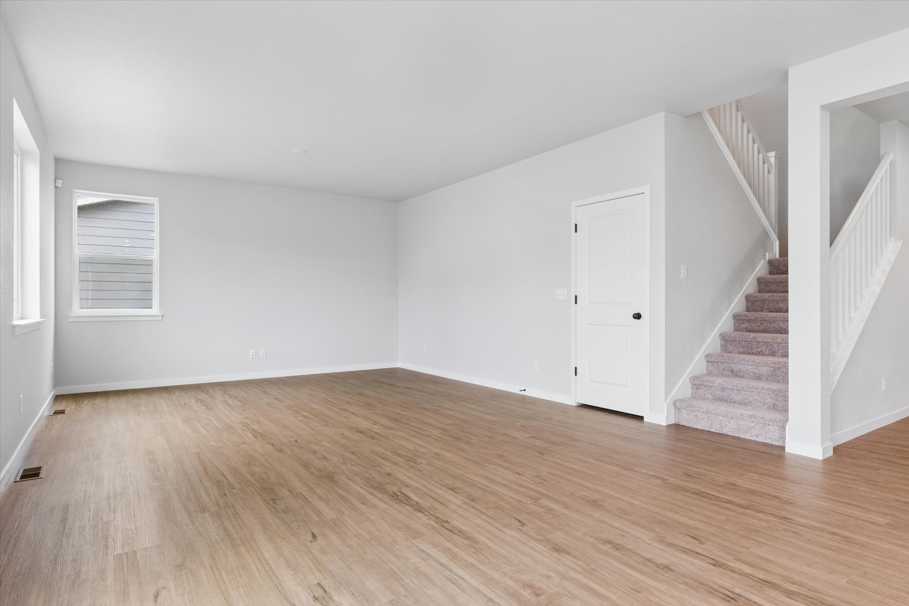 A room with a wood floor and white walls.