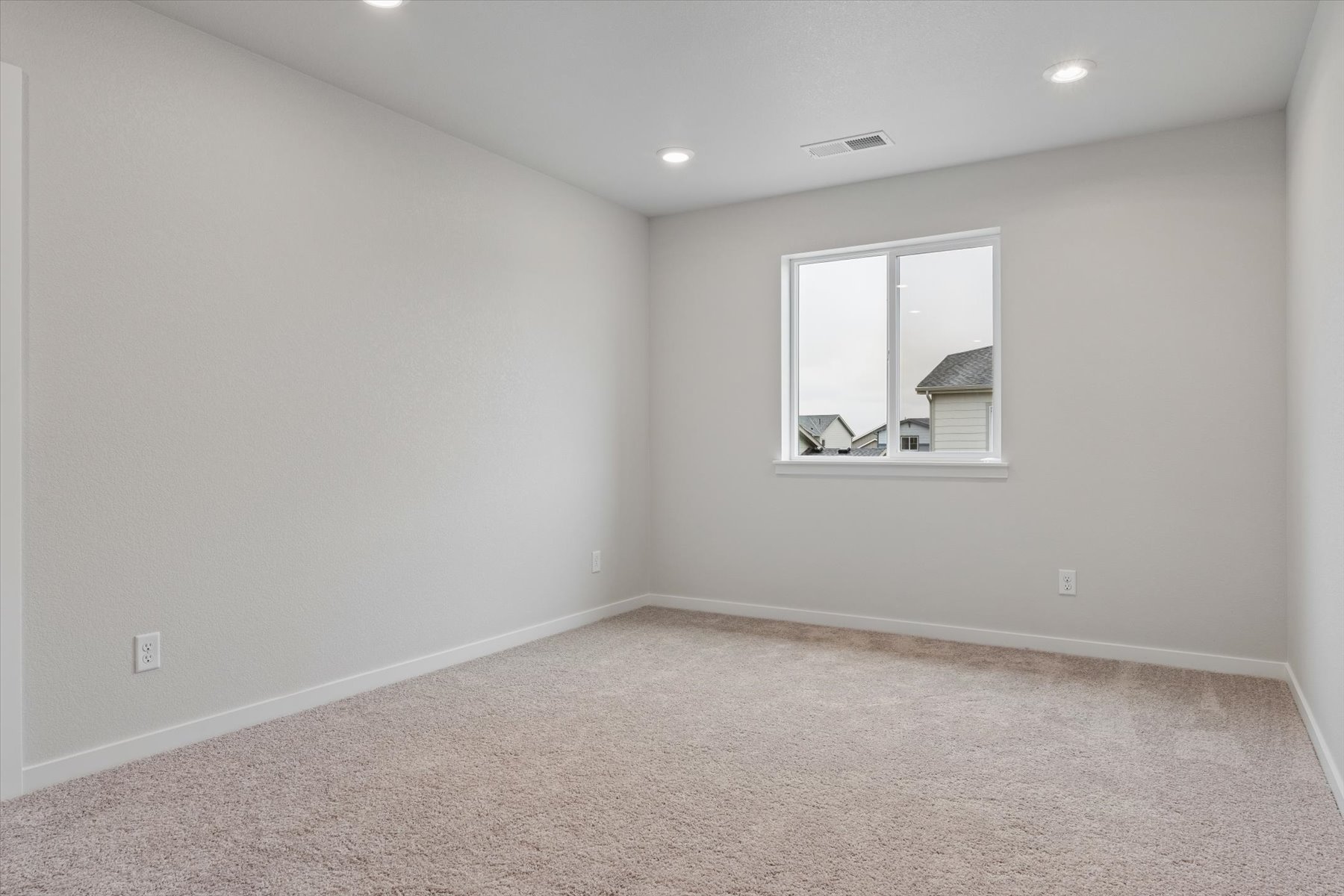 A room with a window and a carpet.