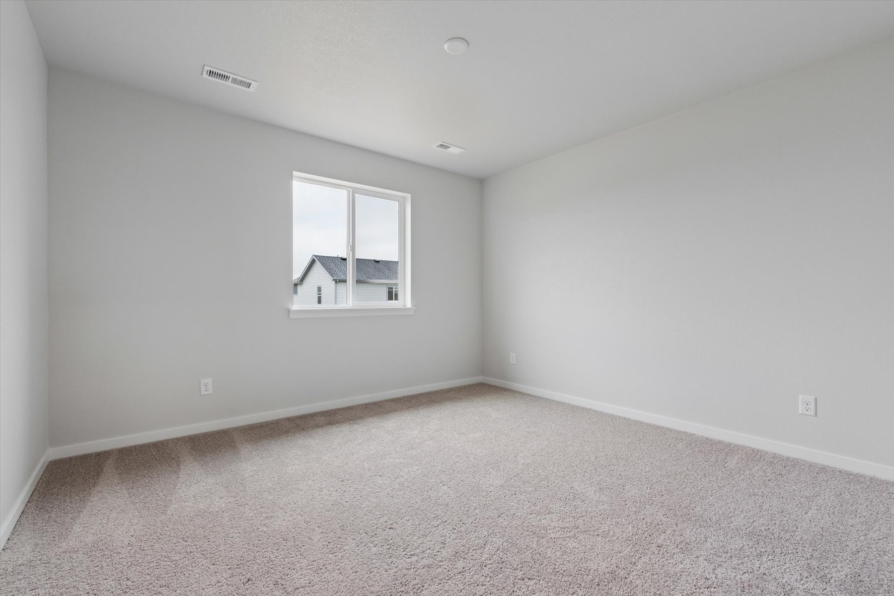 A room with a window and a carpet.
