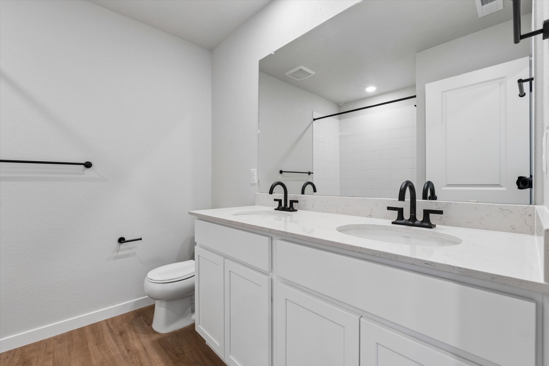 A bathroom with a large mirror.