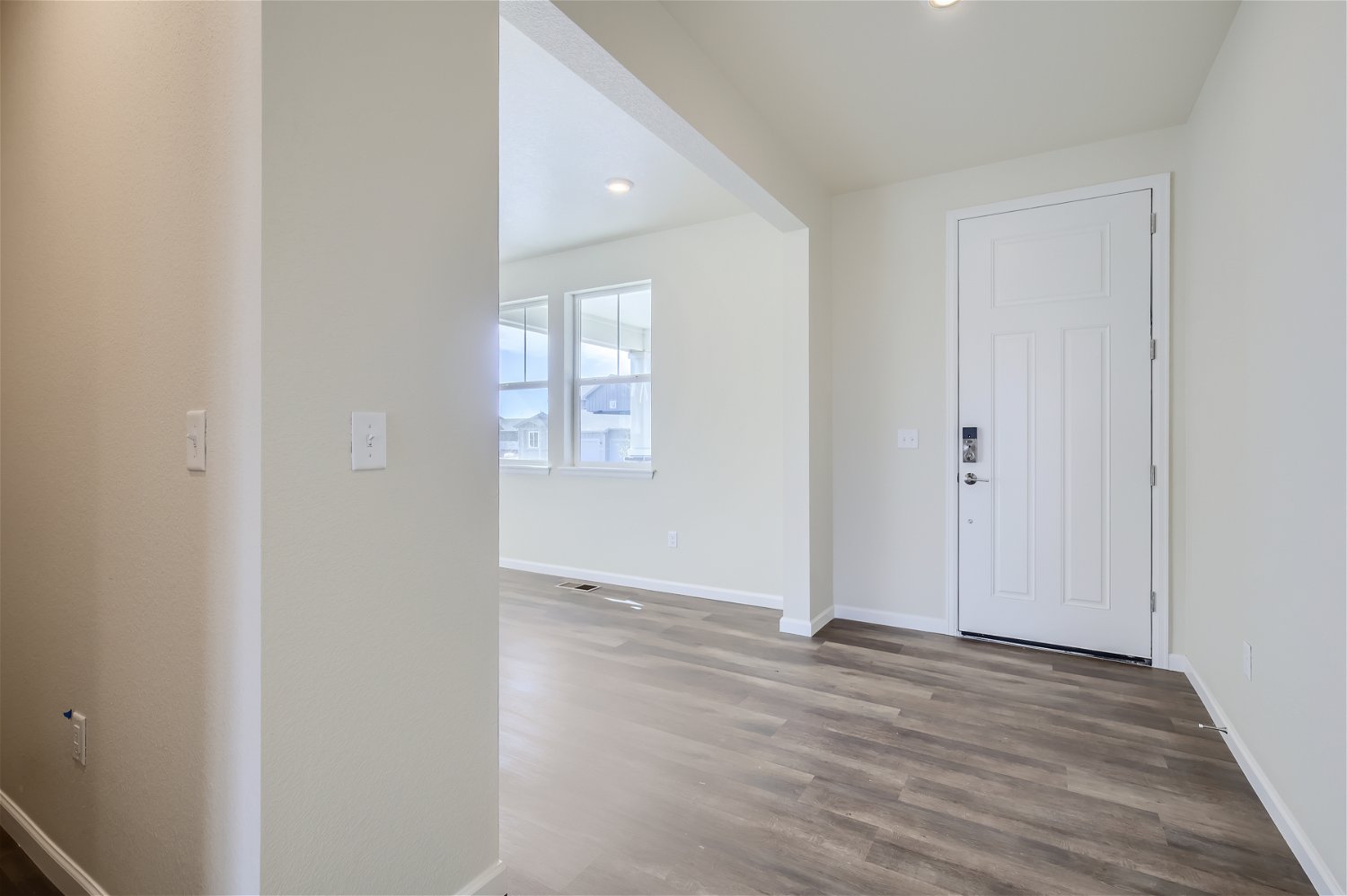 A room with a wood floor and white walls.