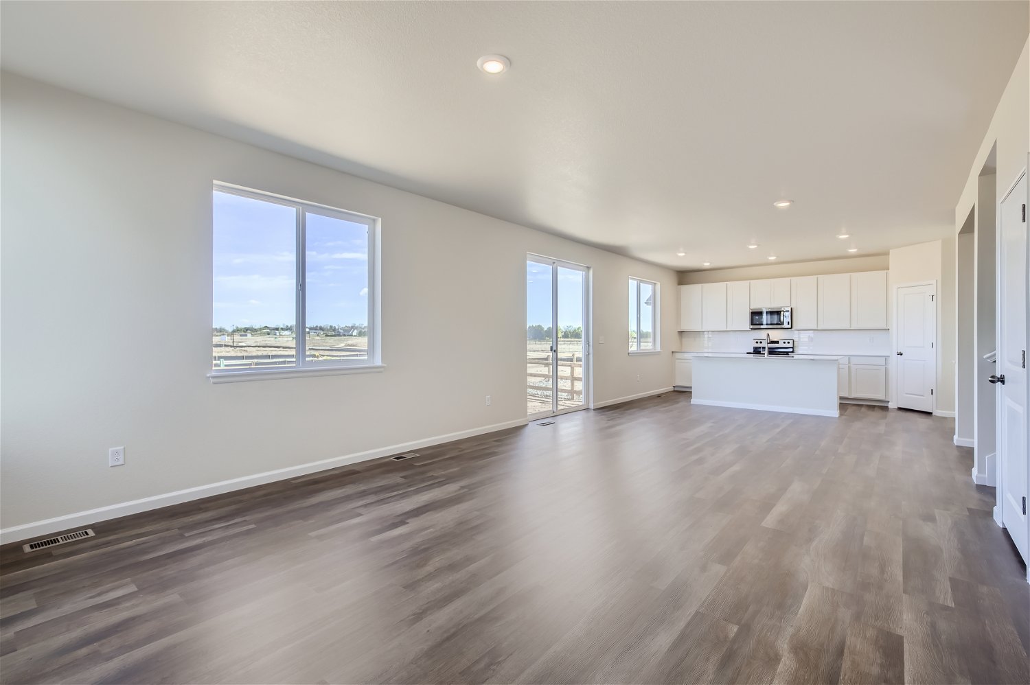 A large empty room with white cabinets.