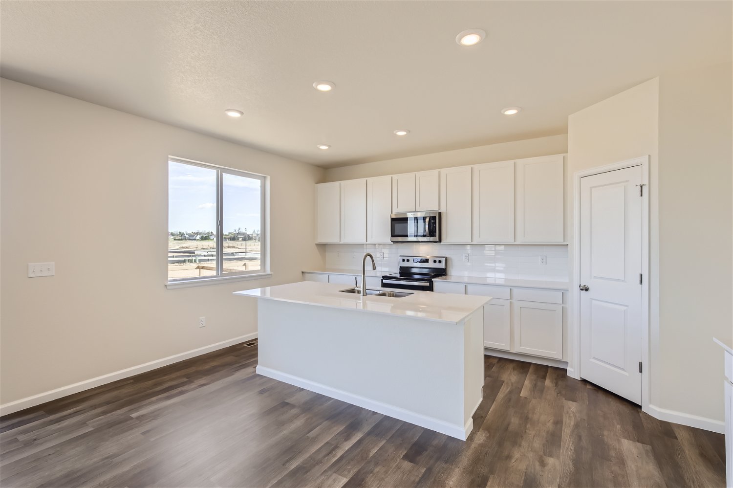 A kitchen with white cabinets.