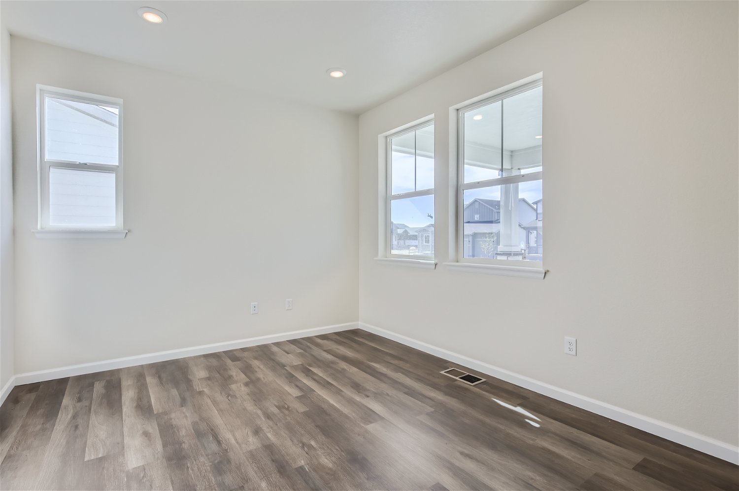A room with a wood floor and windows.