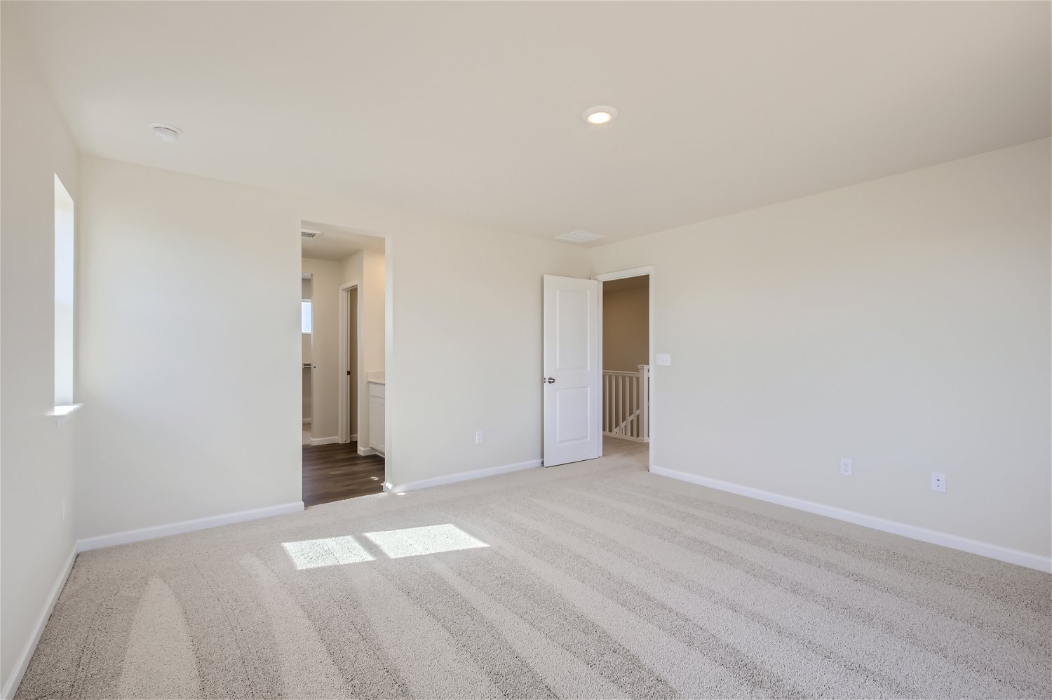 A long hallway with white doors.