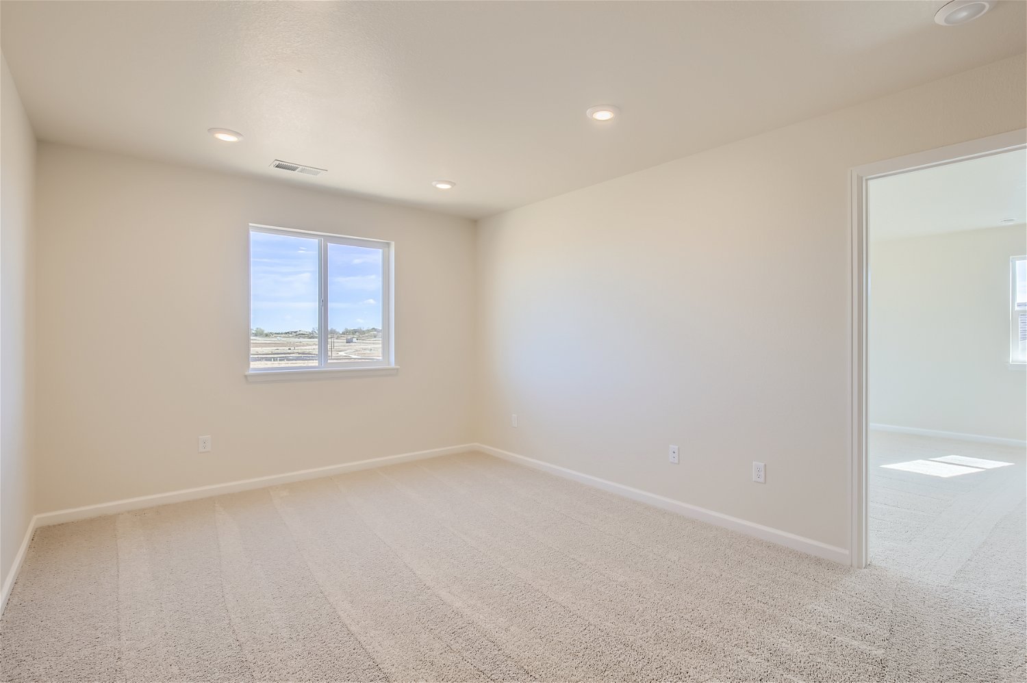 A room with a window and a carpet.