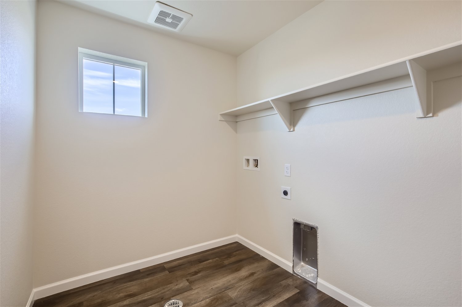 A room with a wood floor and a window.