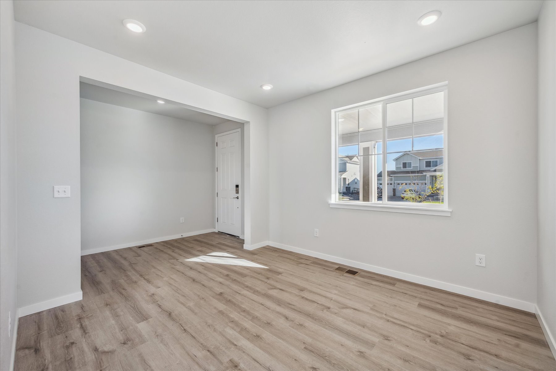 A room with a wood floor and a window.