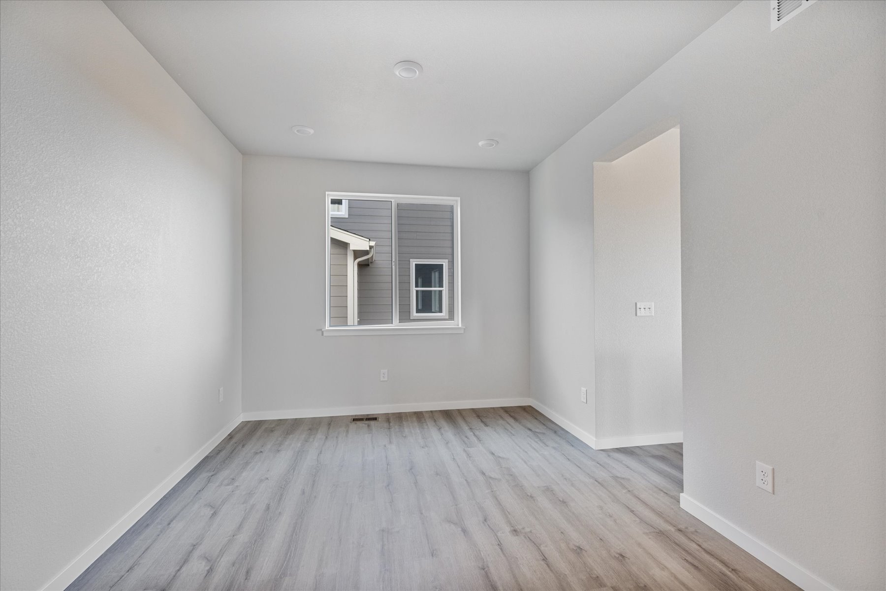 A room with a wood floor and a window.