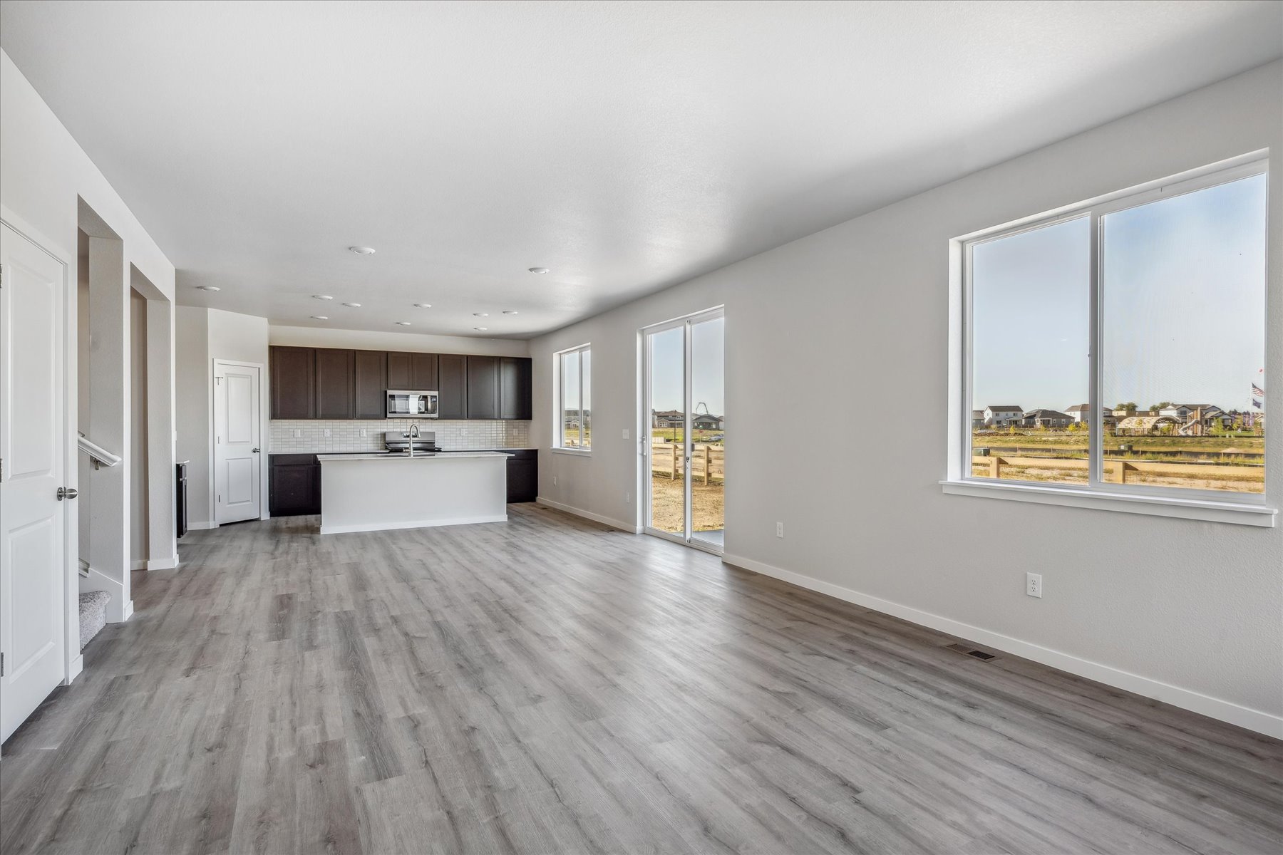 A large empty room with a wood floor and a large window.