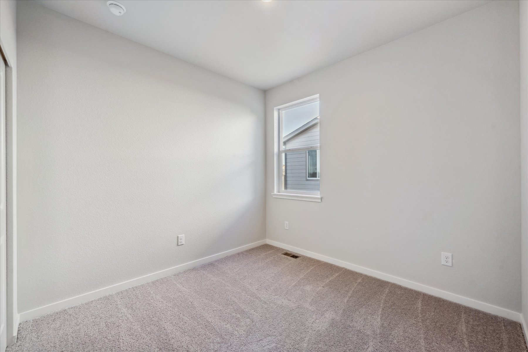 A room with a carpet and a window.
