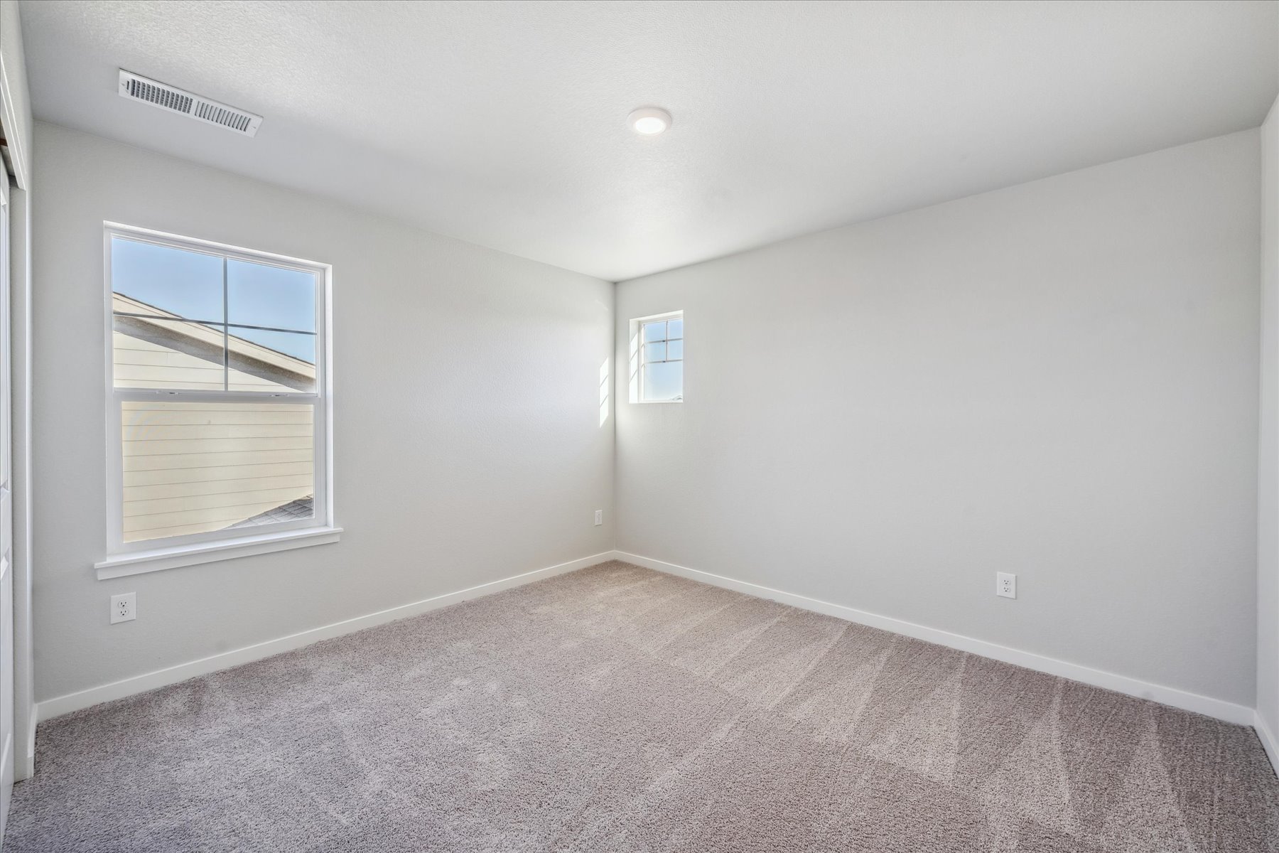 A room with a window and a rug.