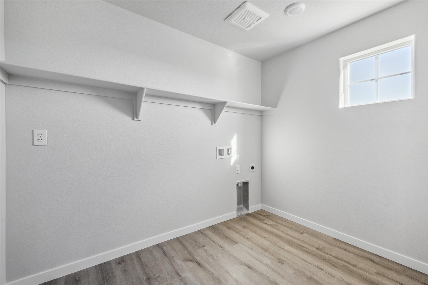 A room with a wood floor and white walls.