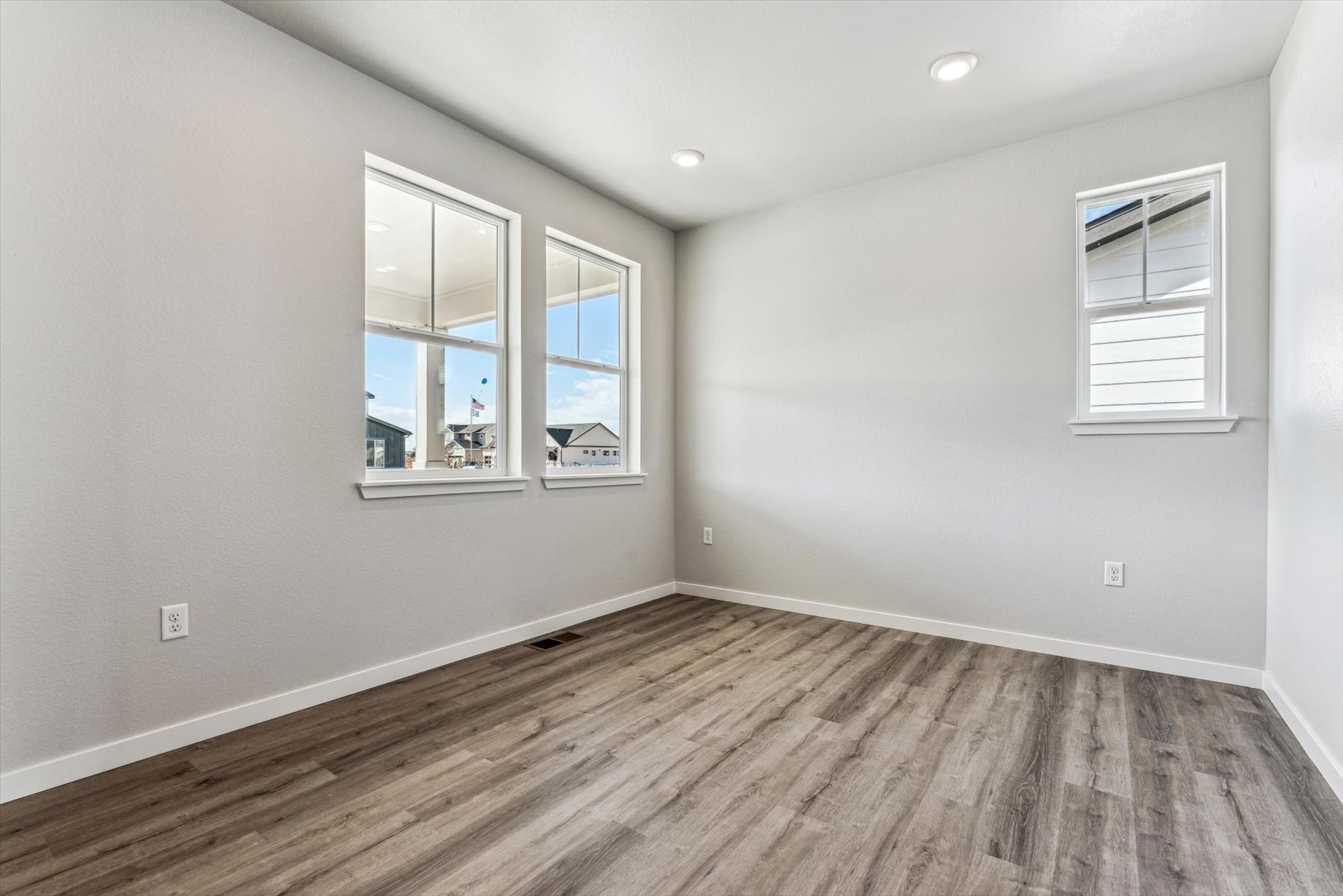 A room with a wood floor and windows.