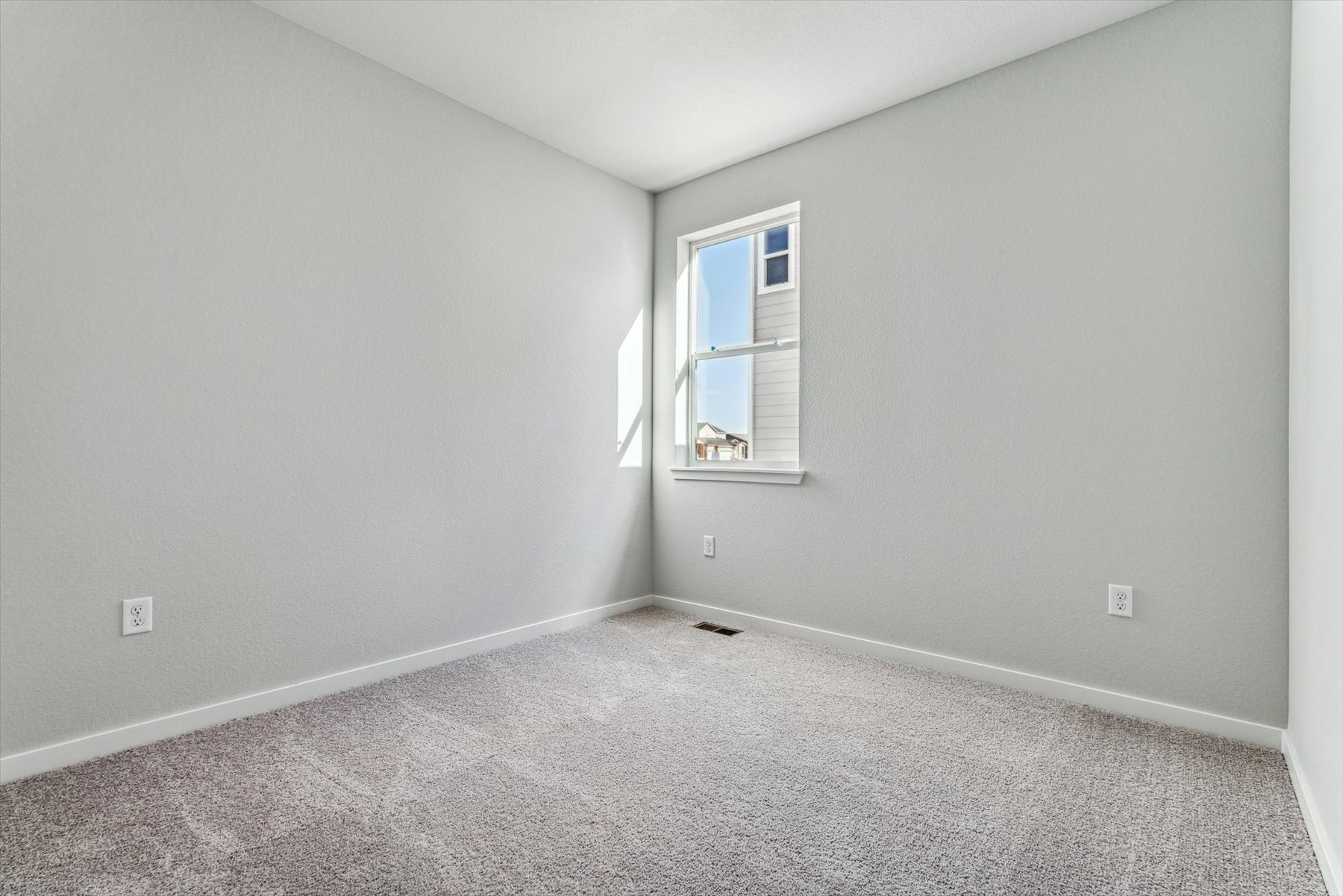 A room with a window and carpet.