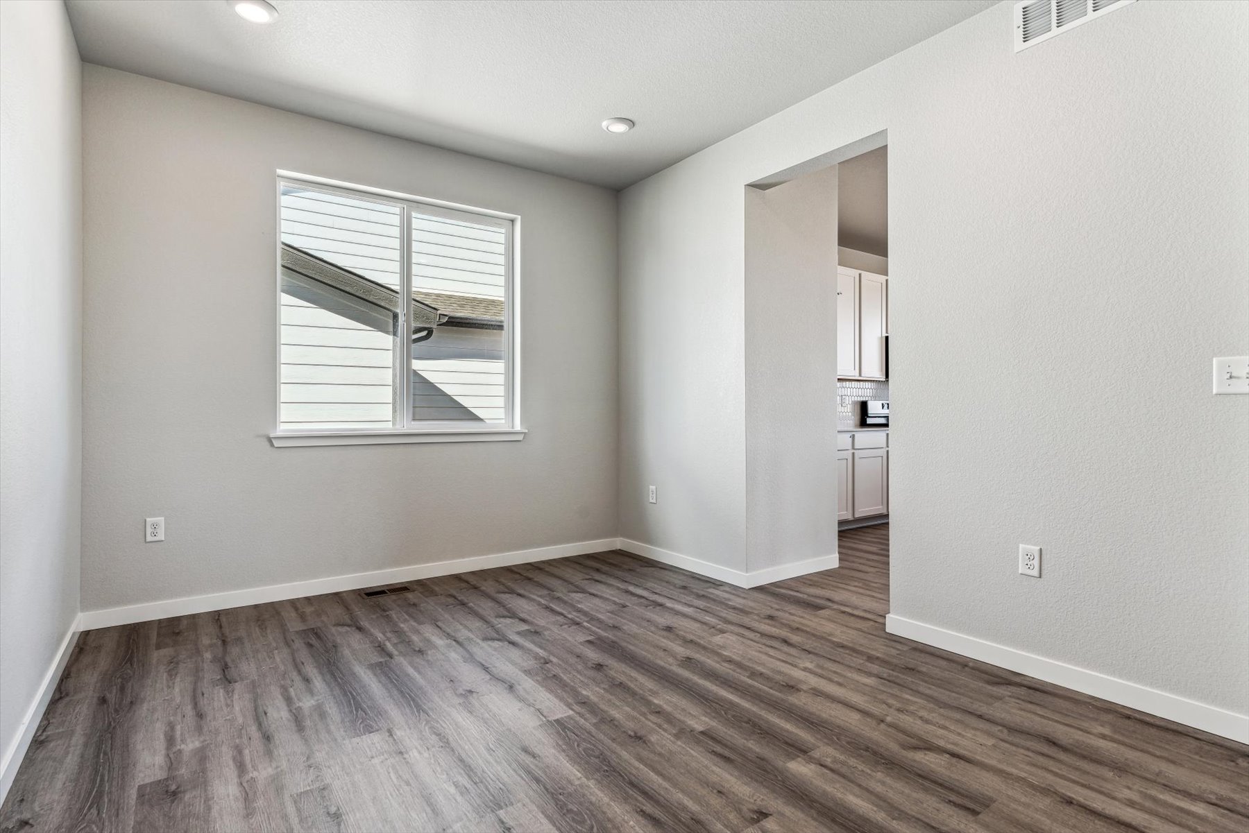 A room with a wood floor and a window.
