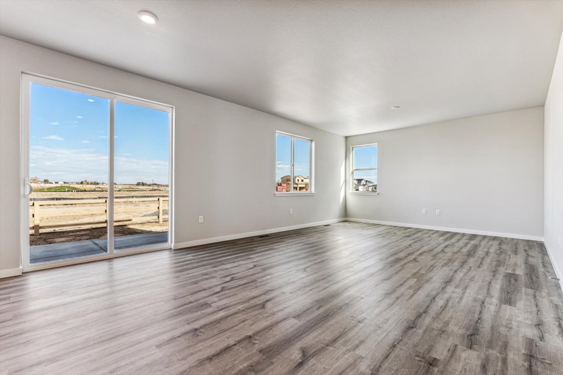 A room with a wood floor and windows.