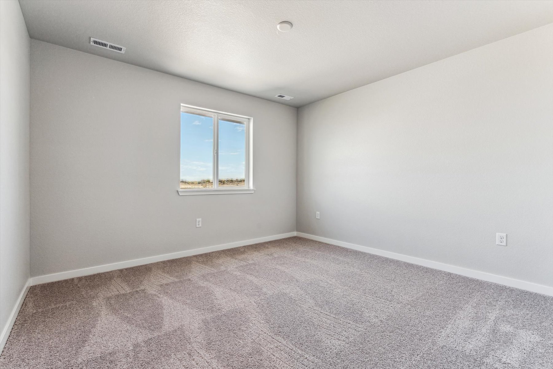 A room with a window and carpet.