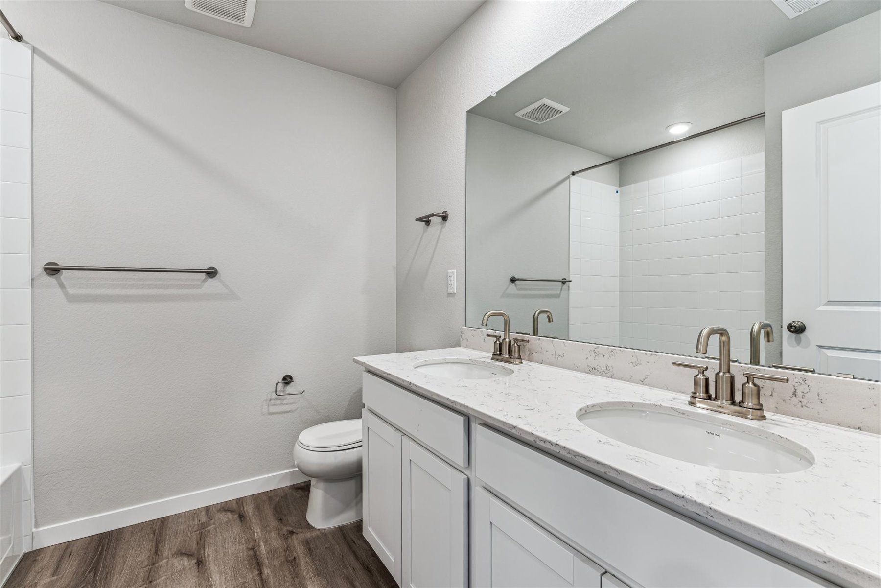 A bathroom with a large mirror.