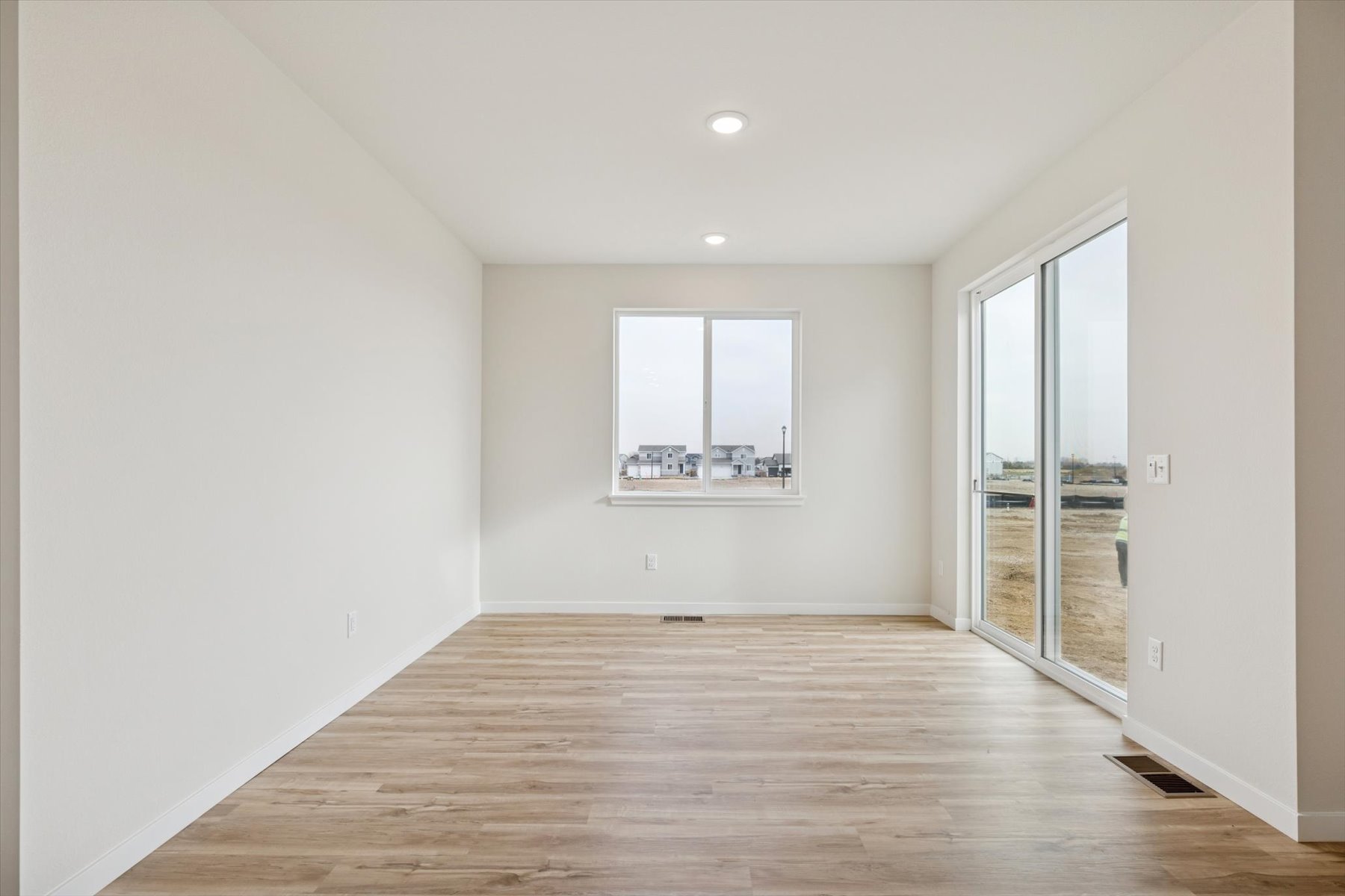 A room with a wood floor and a wood floor with a window.