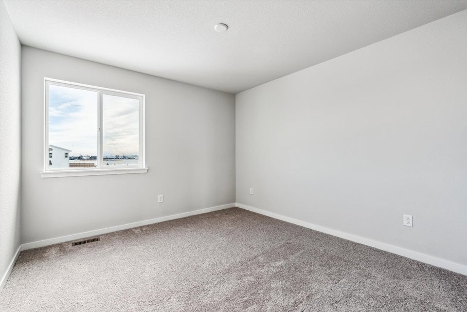 A room with a window and a carpet.