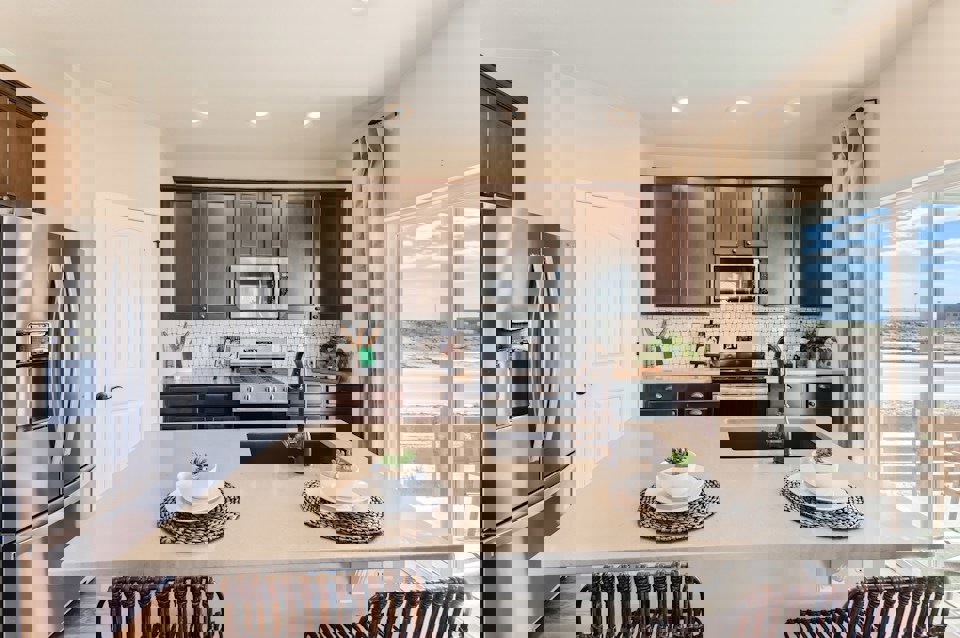 A kitchen with a table and chairs.