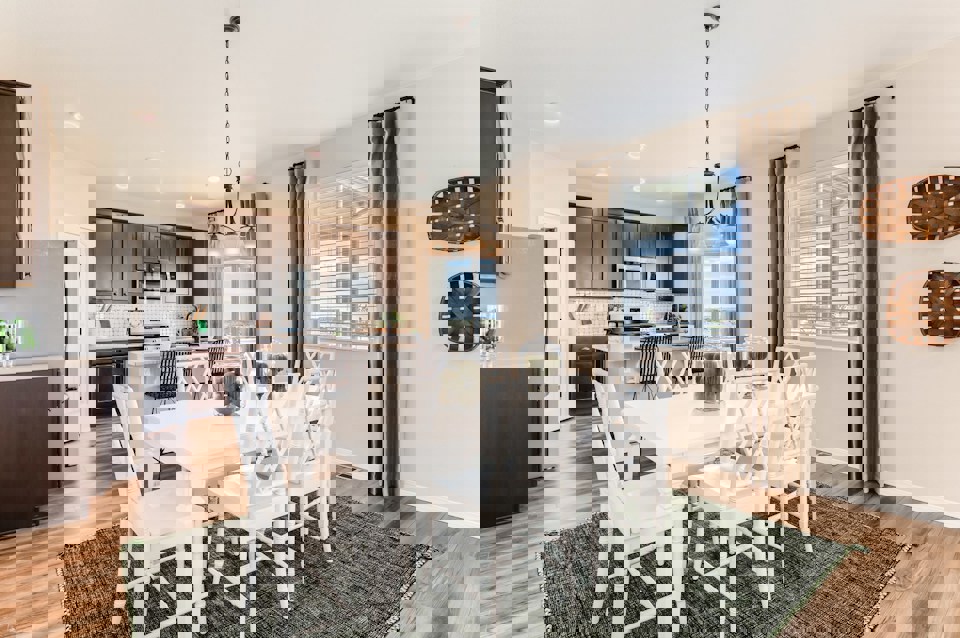 A kitchen with a dining table and chairs.