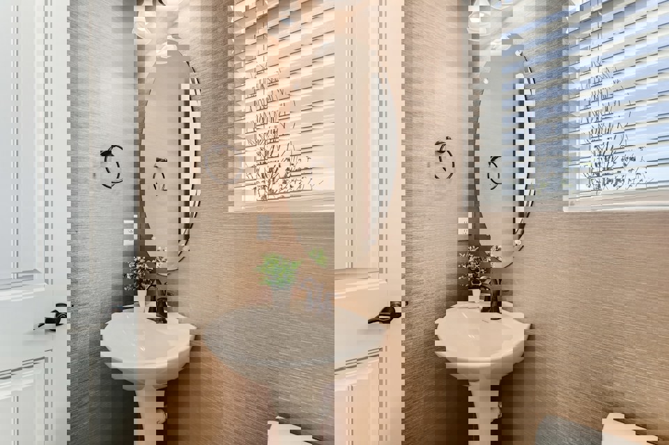 A bathroom with a round mirror.