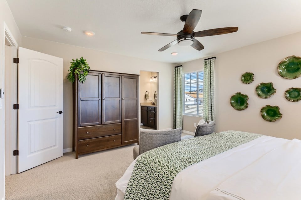 A bedroom with a bed and a fan.