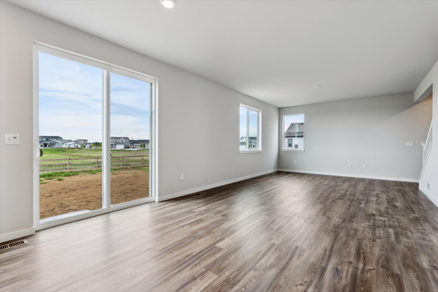 A room with a wood floor and large windows.