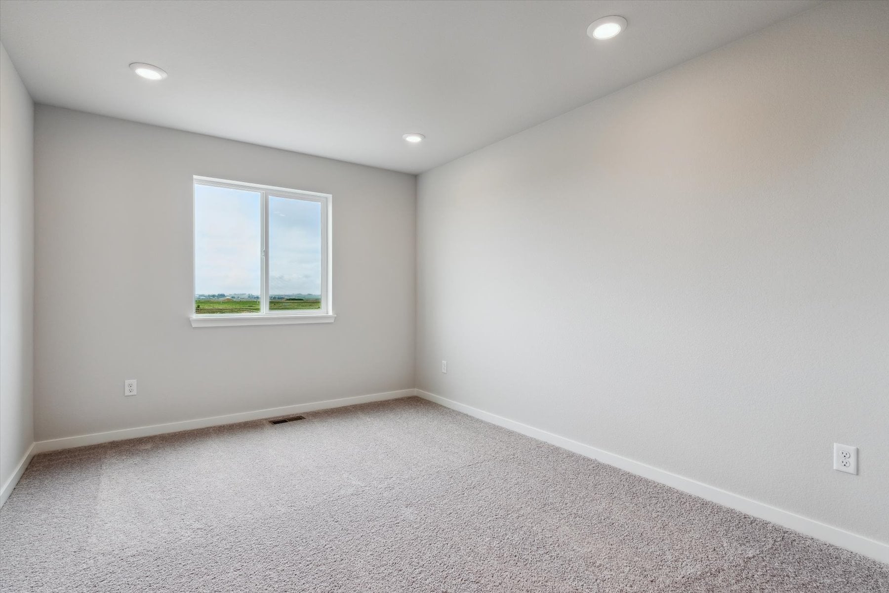 A room with a window and a carpet.