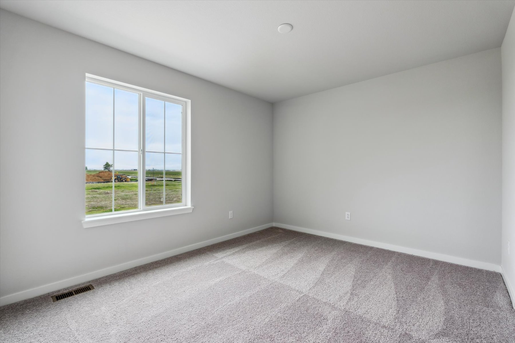 A room with a window and a white wall.