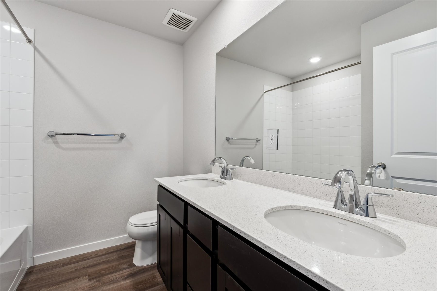 A bathroom with a large mirror.