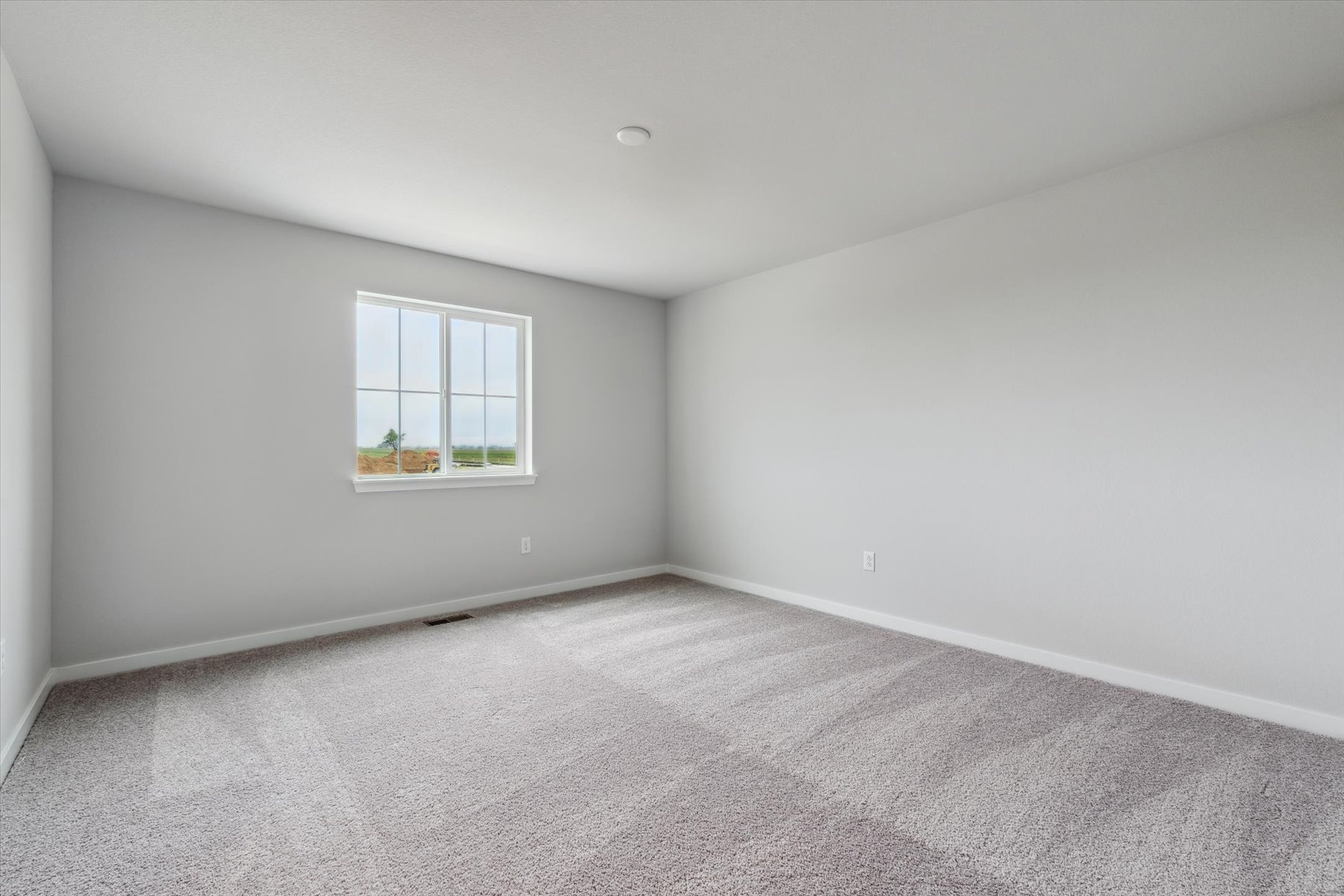 A room with a window and a carpet.