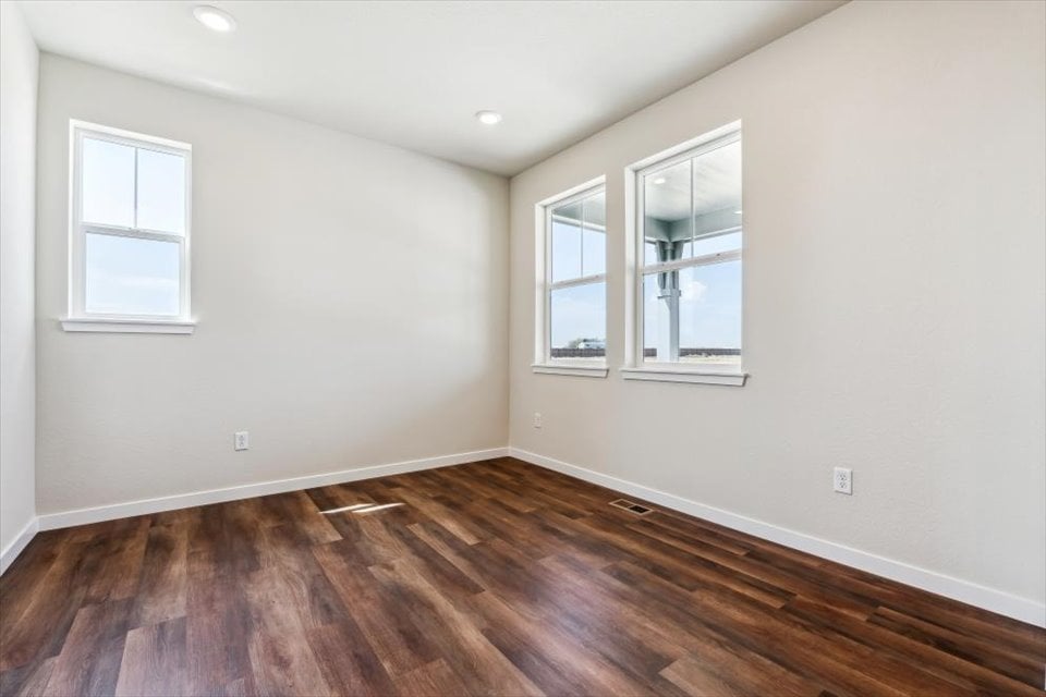 A room with a wood floor and windows.